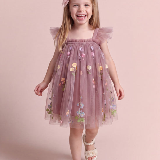 Girl wearing the Aurora Dress in dusty mauve embroidered floral tulle, front