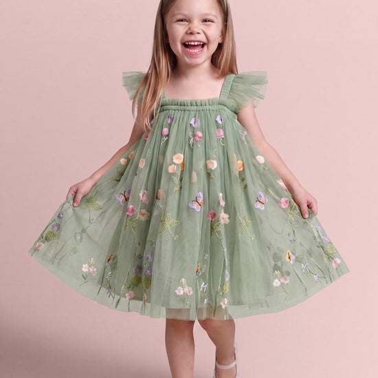 Girl wearing the Aurora Dress in sage green embroidered floral tulle, front