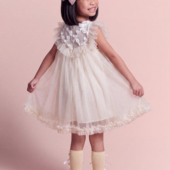 Back view of the Primrose ivory dress, the crochet yoke carrying its gauze roses across the shoulders