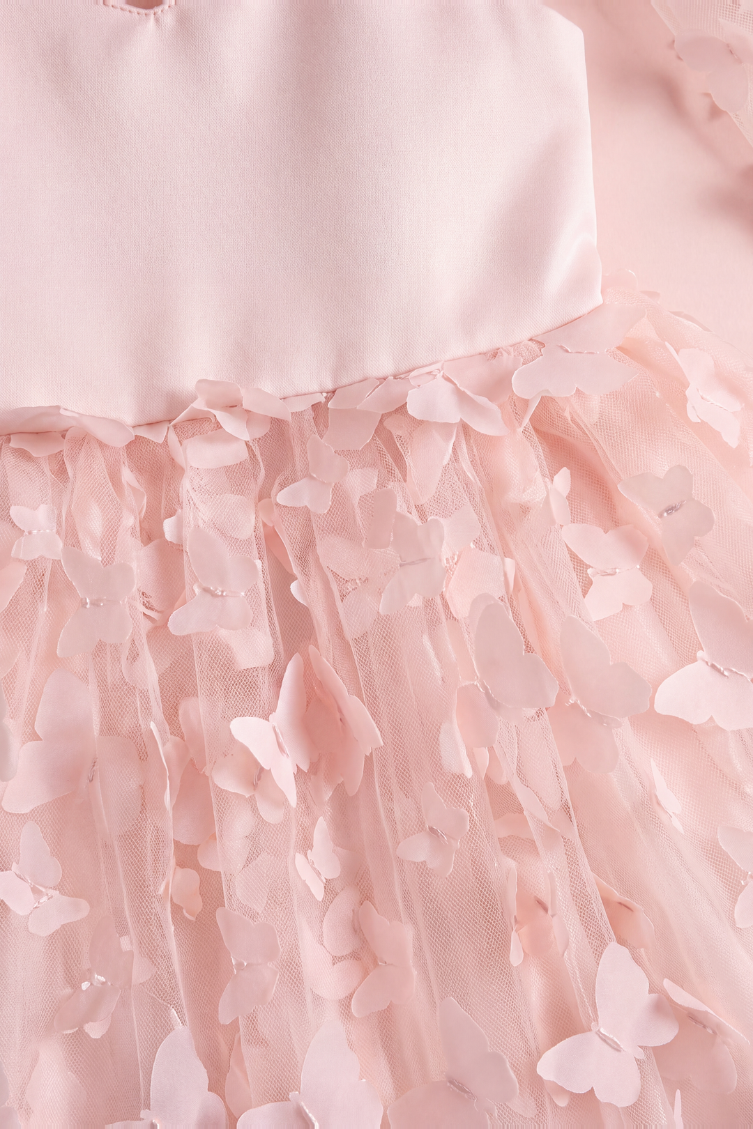 Close up of the Blossom dress waist seam and the two layer fabric butterflies lifting off the tulle