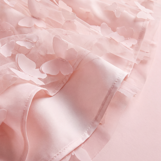 Close up of the Blossom dress hem, sheer butterfly tulle over the satin lining