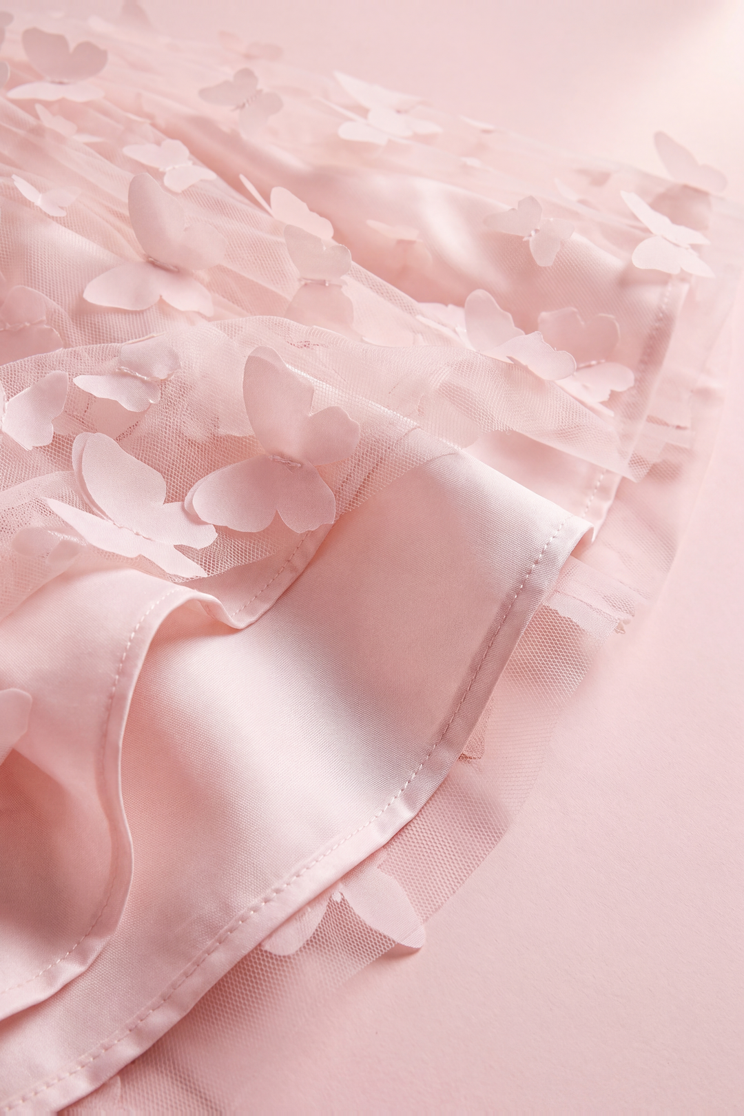 Close up of the Blossom dress hem, sheer butterfly tulle over the satin lining