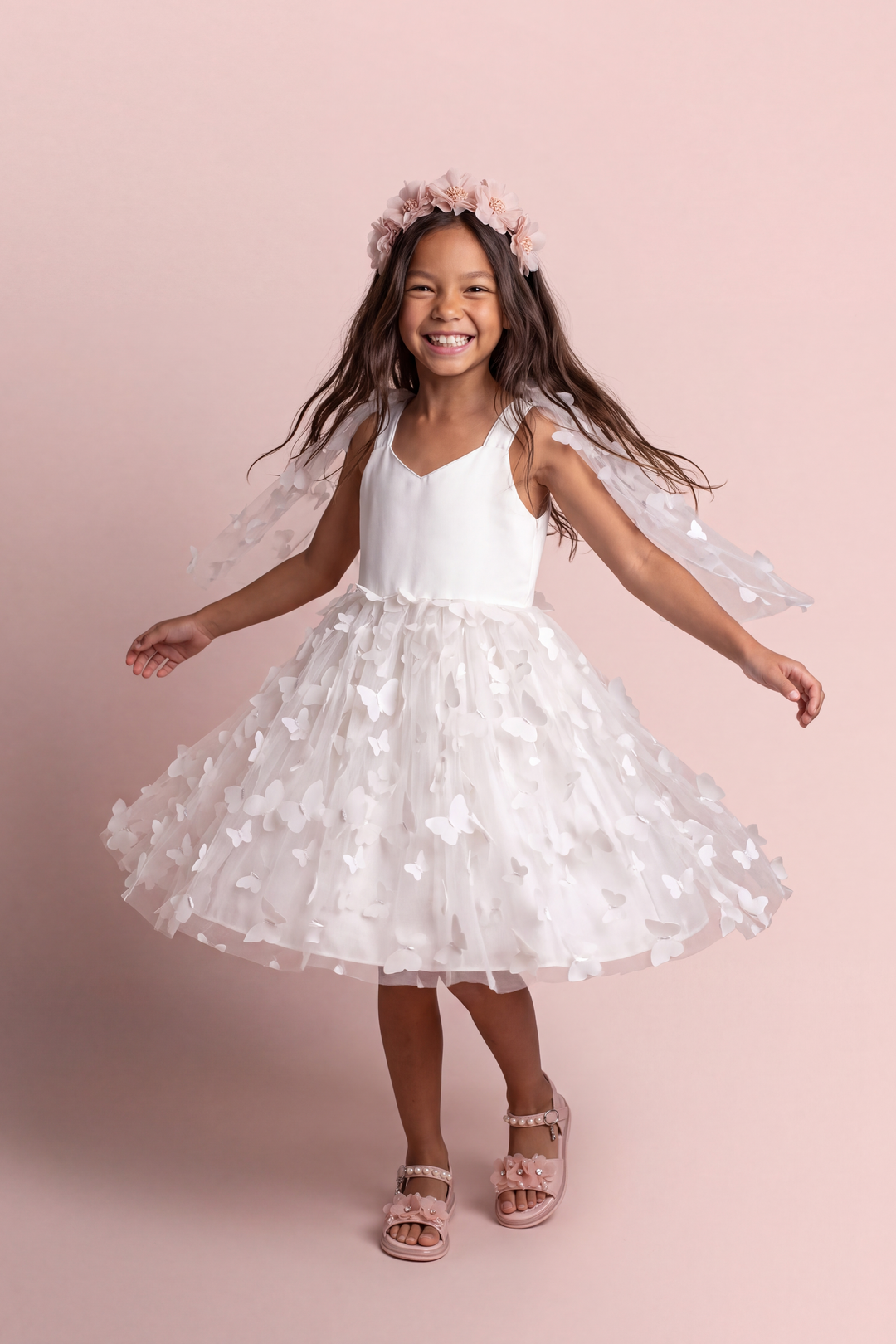 Blossom white butterfly party dress, front view on a girl mid twirl, satin sweetheart bodice and tulle skirt covered in 3D fabric butterflies