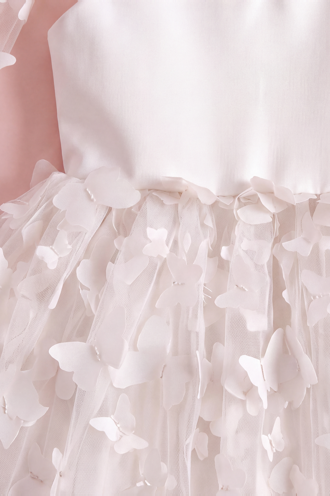 Close up of the Blossom white dress waist seam and the two layer fabric butterflies lifting off the tulle