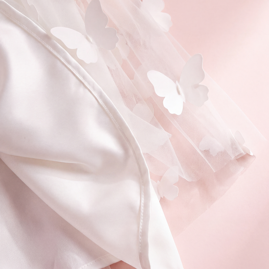 Close up of the Blossom white dress hem, sheer butterfly tulle over the satin lining