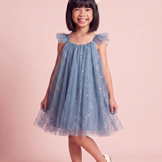 Girl wearing the Bluebell Star Dress in blue star tulle, front