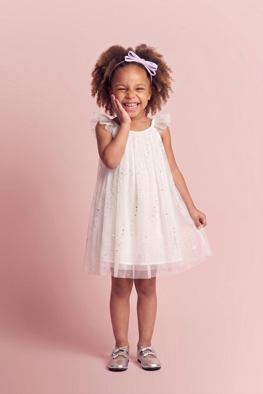 Girl wearing the Bluebell Star Dress in white star tulle, front