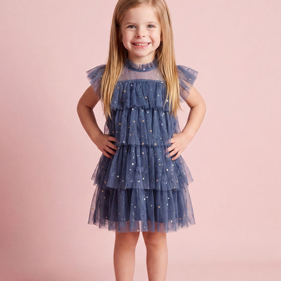 Girl wearing the Celeste Dress in denim blue star tulle, front