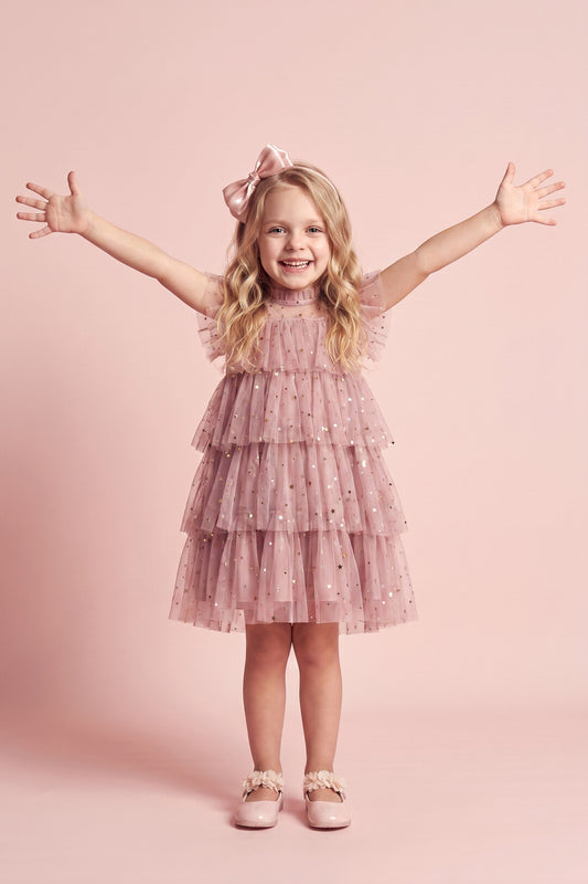 Girl wearing the Celeste Dress in dusty pink star and moon tulle, front