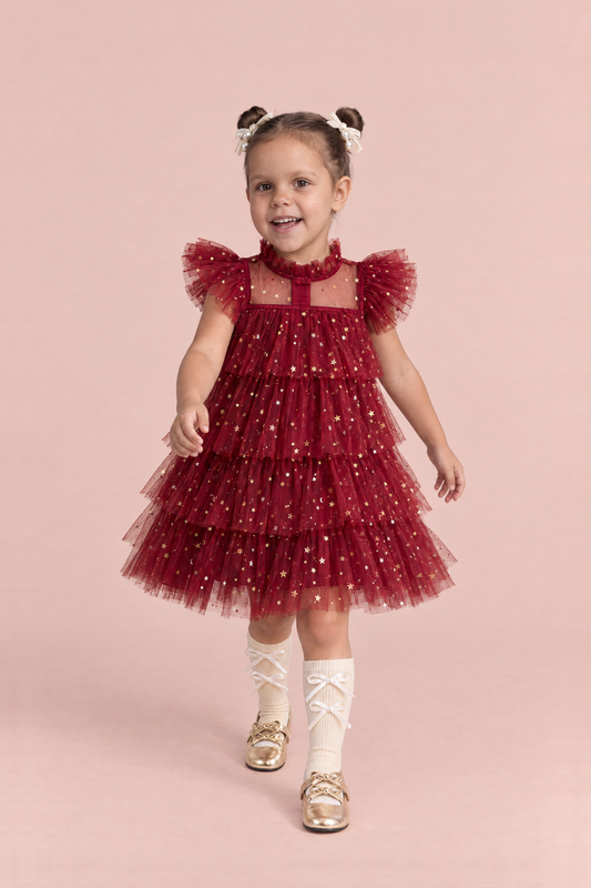 Girl wearing the Celeste Wine Red Flower Girl Dress, front, walking toward the camera with a big smile