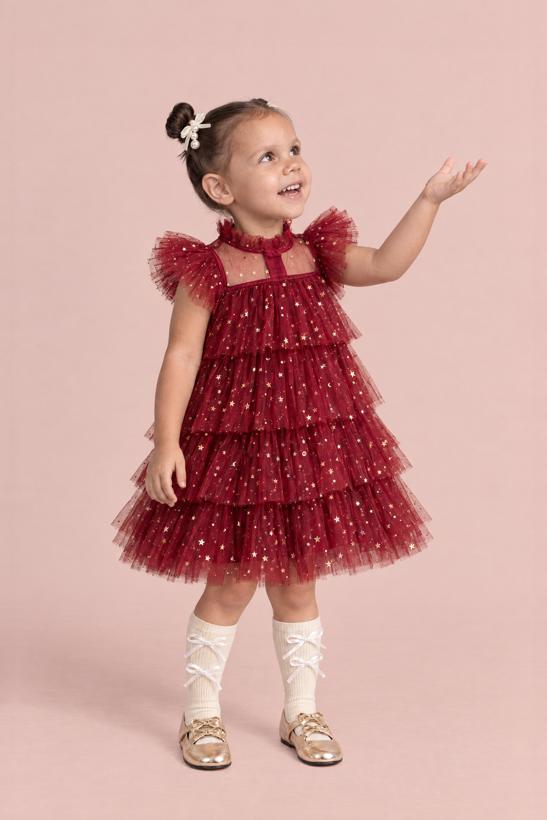 Celeste Wine Red Flower Girl Dress, three quarter view, reaching up to catch a snowflake