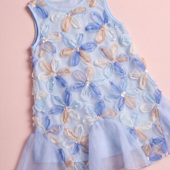 Cornflower Dress laid flat, pale blue mesh covered in applique organza flowers