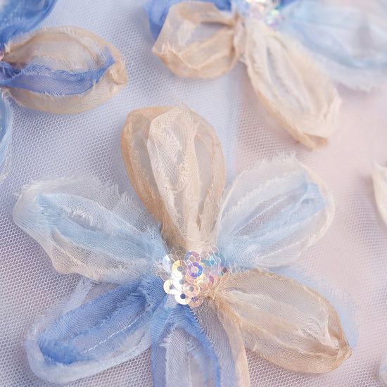 Close up of the applique organza flowers with sequin centres on pale blue mesh