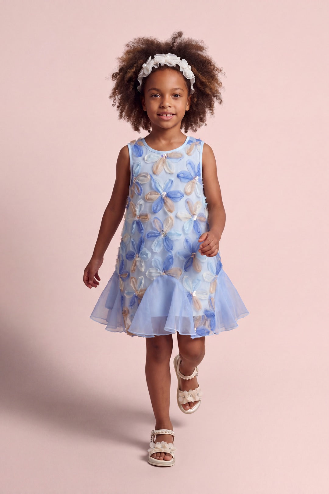 Girl wearing the Cornflower Dress in pale blue mesh with applique flowers, front