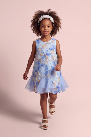 Girl wearing the Cornflower Dress in pale blue mesh with applique flowers, front
