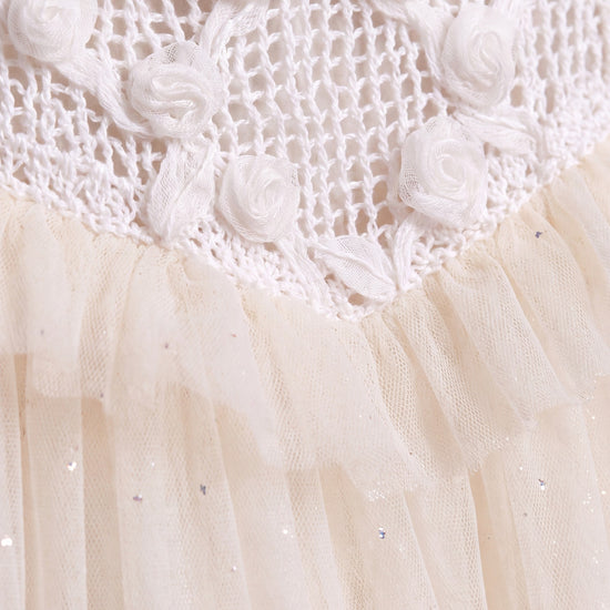 Close up of the Primrose fabric, translucent gauze roses on open crochet above glitter flecked ivory tulle