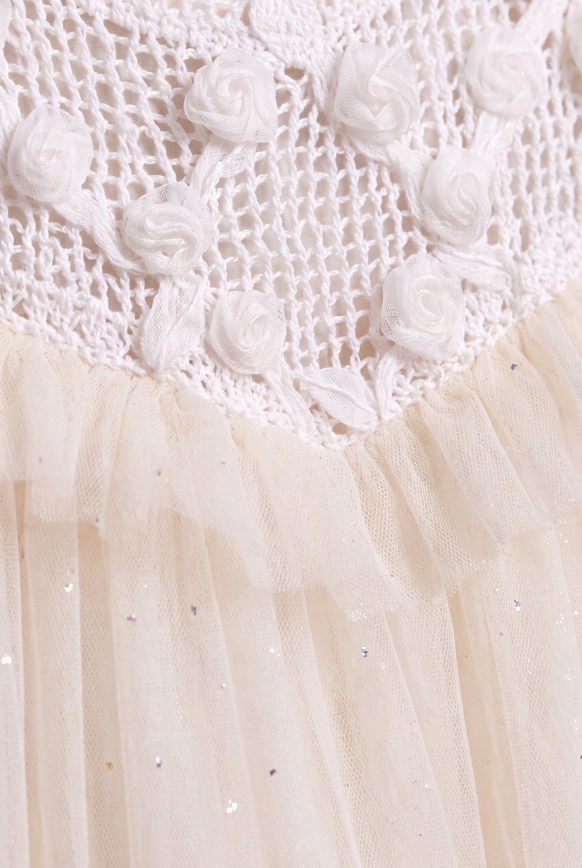 Close up of the Primrose fabric, translucent gauze roses on open crochet above glitter flecked ivory tulle