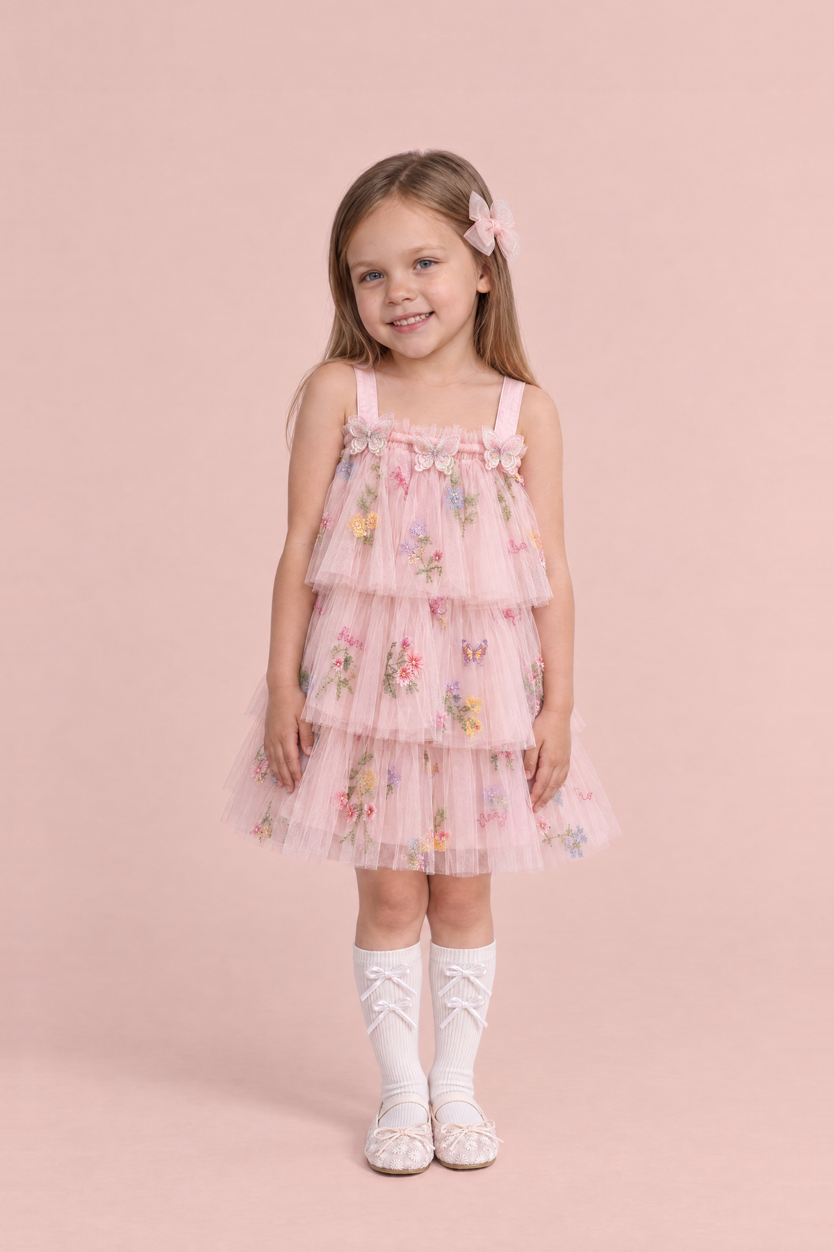 Girl wearing the Flutter Blush Butterfly Flower Girl Dress, front