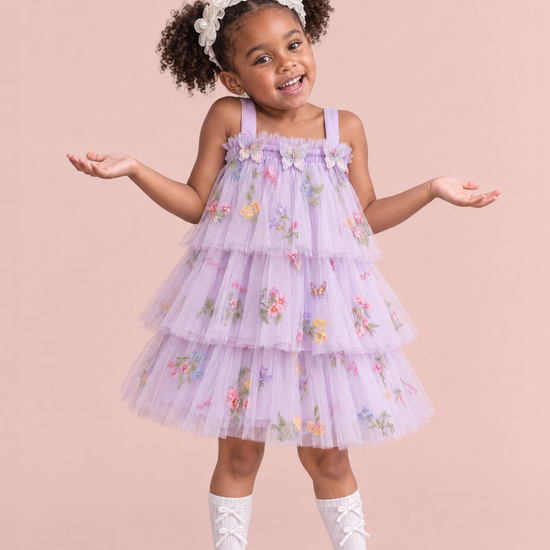 Girl wearing the Flutter Lilac Butterfly Flower Girl Dress, front, a big shrug