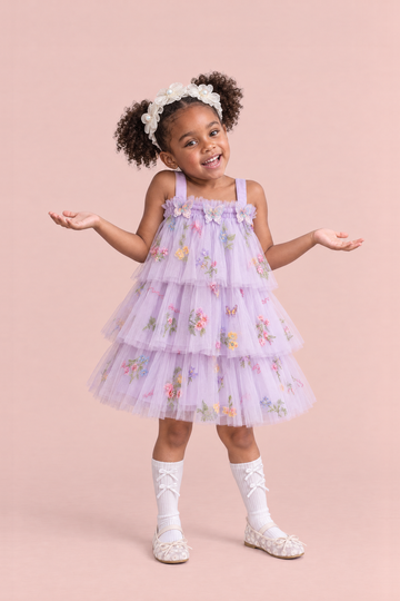 Girl wearing the Flutter Lilac Butterfly Flower Girl Dress, front, a big shrug