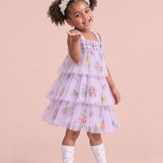 Flutter Lilac Butterfly Flower Girl Dress, three quarter, blowing a kiss, organza butterflies and tiers