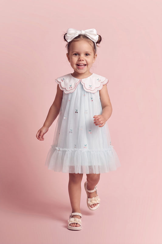 Girl wearing the Forget Me Not Dress in powder blue with cherry collar, front