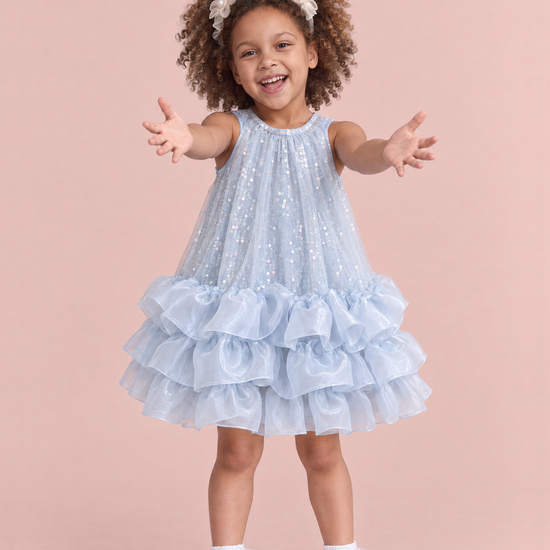 Girl wearing the Glacier Ice Blue Sequin Ruffle Party Dress, front, both arms reaching out to be picked up