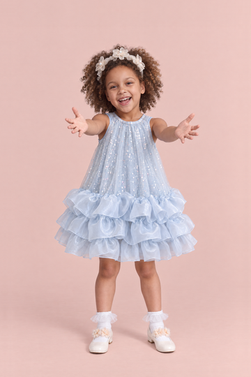 Girl wearing the Glacier Ice Blue Sequin Ruffle Party Dress, front, both arms reaching out to be picked up
