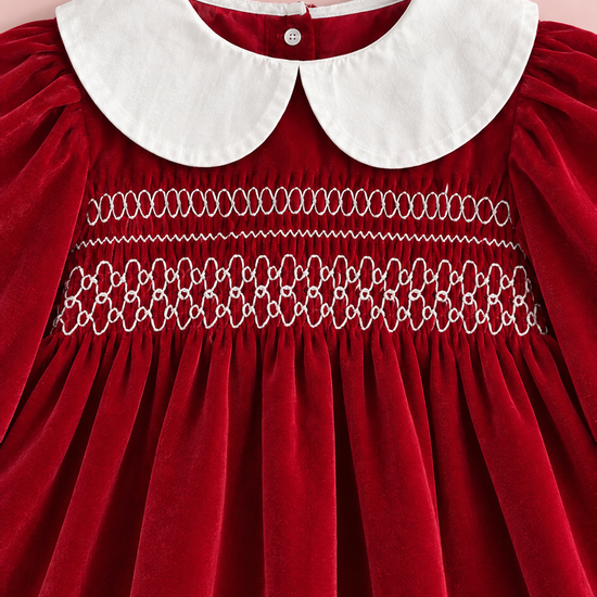 Close up of the white Peter Pan collar and the three rows of white embroidery on the smocked red velvet bodice