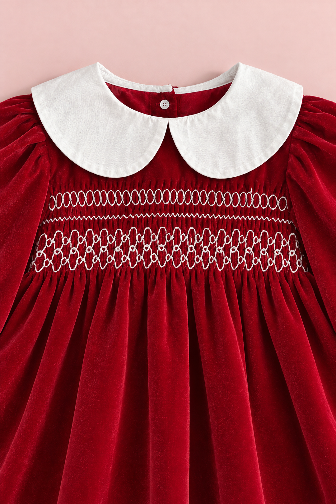 Close up of the white Peter Pan collar and the three rows of white embroidery on the smocked red velvet bodice