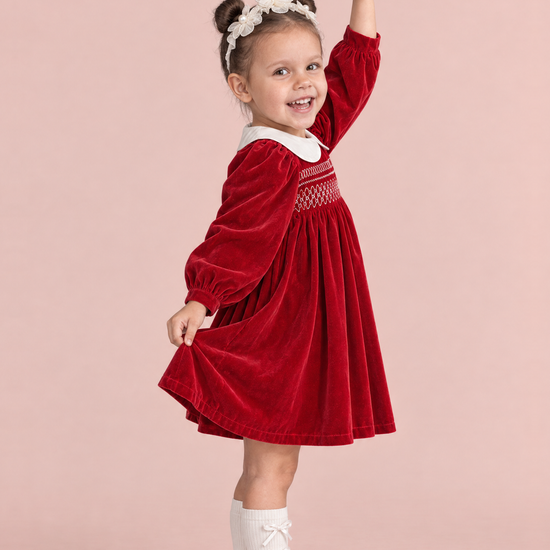 Holly Red Velvet Christmas Dress, side view in a ballerina pose, showing the long puff sleeve and the full gathered skirt