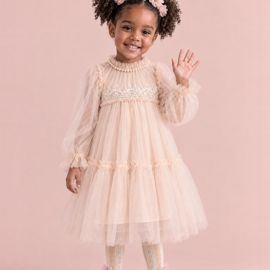 Girl wearing the Magnolia Champagne Long Sleeve Flower Girl Dress, front