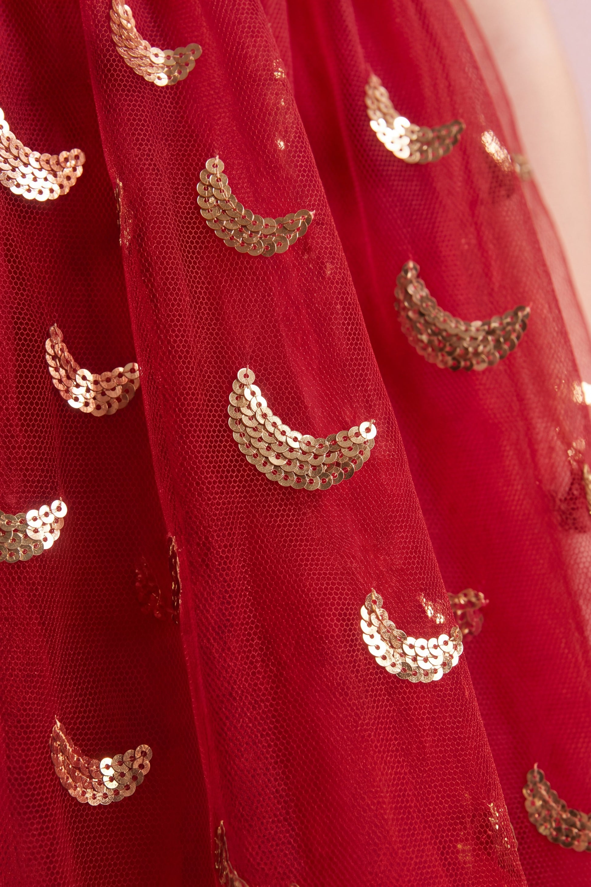 Close up of the red tulle and gold crescent moon sequins