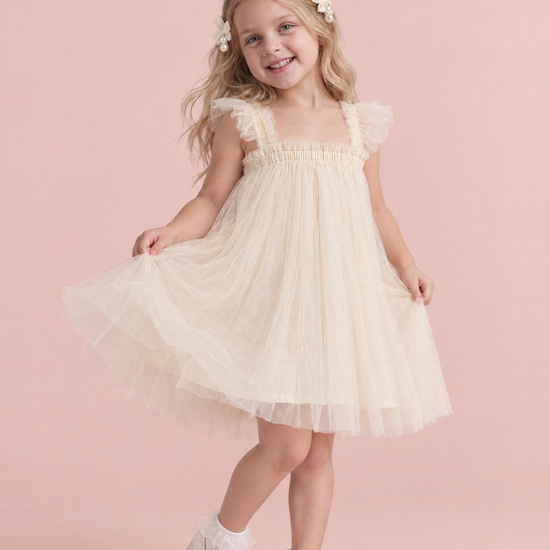 Girl wearing the Papillon Ivory Butterfly Back Flower Girl Dress, front, swishing the skirt