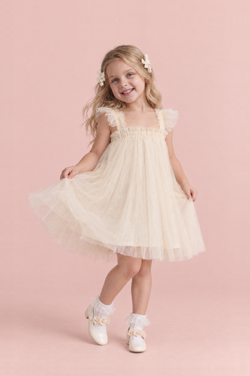 Girl wearing the Papillon Ivory Butterfly Back Flower Girl Dress, front, swishing the skirt