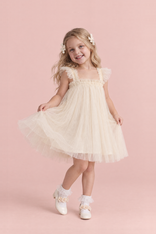 Girl wearing the Papillon Ivory Butterfly Back Flower Girl Dress, front, swishing the skirt