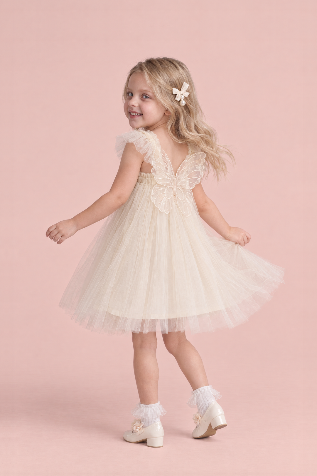 Papillon Ivory Butterfly Back Flower Girl Dress, turning to show the organza butterfly across her back