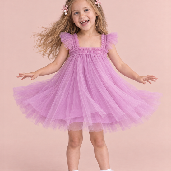 Girl wearing the Papillon Orchid Butterfly Back Flower Girl Dress, front, mid twirl with the skirt flying