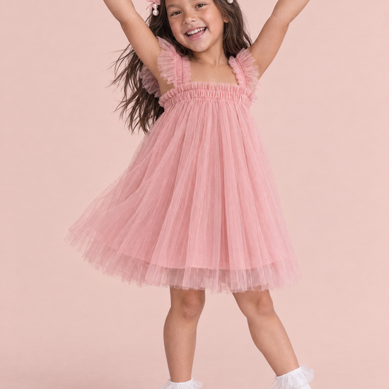 Girl wearing the Papillon Dusty Rose Butterfly Back Flower Girl Dress, front, arms up in a ta da