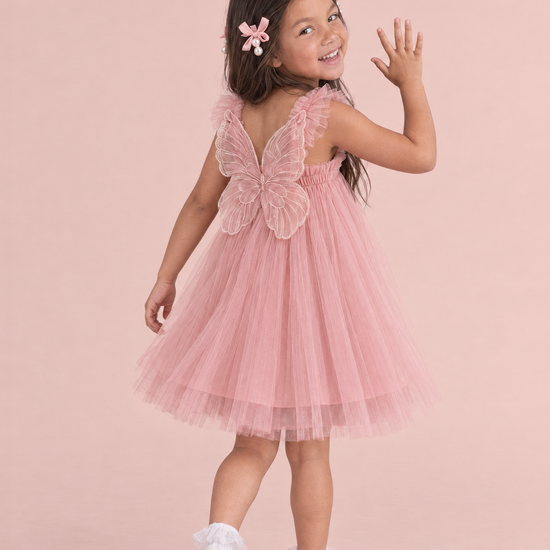 Papillon Dusty Rose Butterfly Back Flower Girl Dress, walking away and waving back, the organza butterfly across her back
