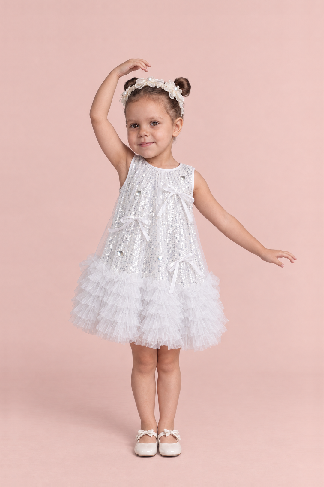 Periwinkle Silver Sequin Party Dress, front: a girl dancing in the white and silver sequin dress with a ruffle hem