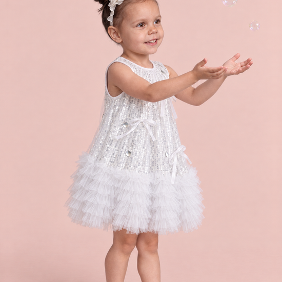 Periwinkle Silver Sequin Party Dress, three quarter view with long tailed satin bows and silver discs on the front
