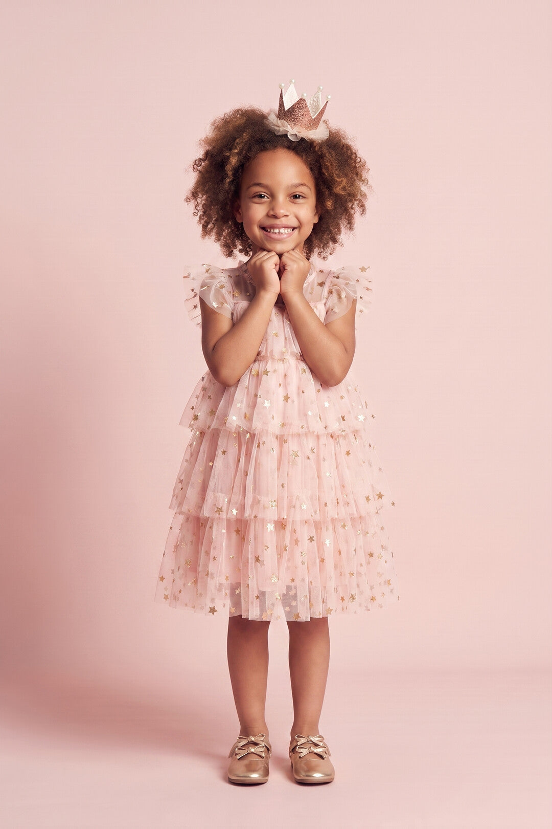 Girl wearing the Petal Star Dress in blush pink star tulle, front