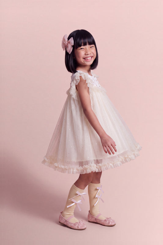Three quarter view of the Primrose Ivory Crochet Flower Girl Dress showing the depth of the tulle skirt