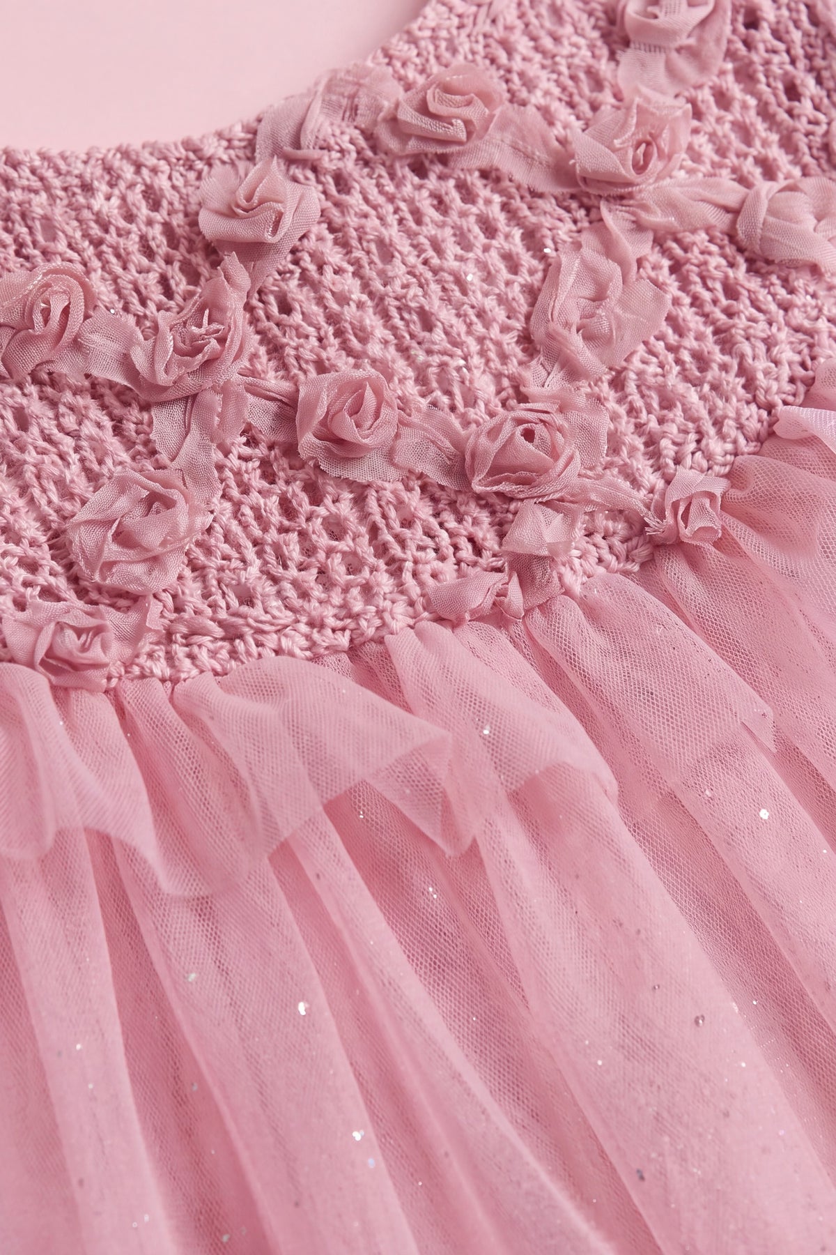Close up of the hand twisted gauze roses, trailing stems and leaves on the crochet yoke