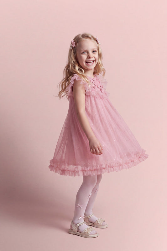 Primrose pink flower girl dress seen at three quarter angle, full tulle skirt in motion