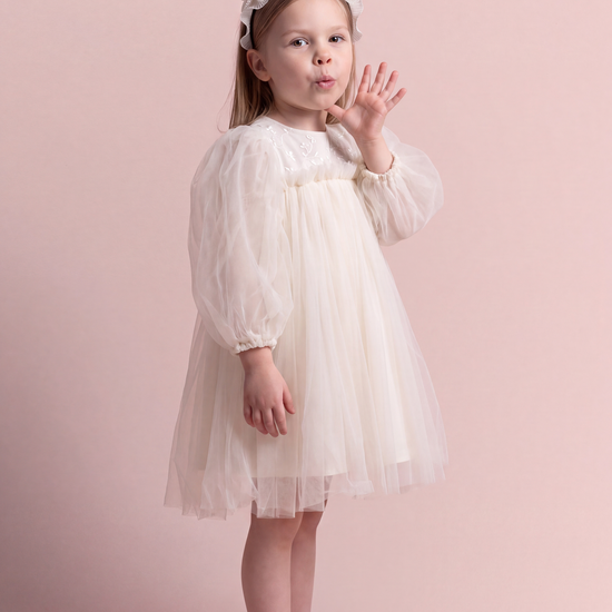 Snowdrop ivory puff sleeve party dress, three quarter view showing the puffed sleeve and the full tulle skirt
