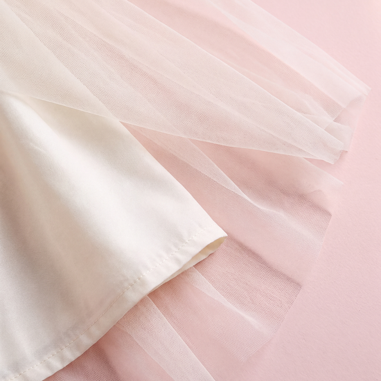 Close up of the Snowdrop dress hem, layers of sheer ivory tulle over the cream lining