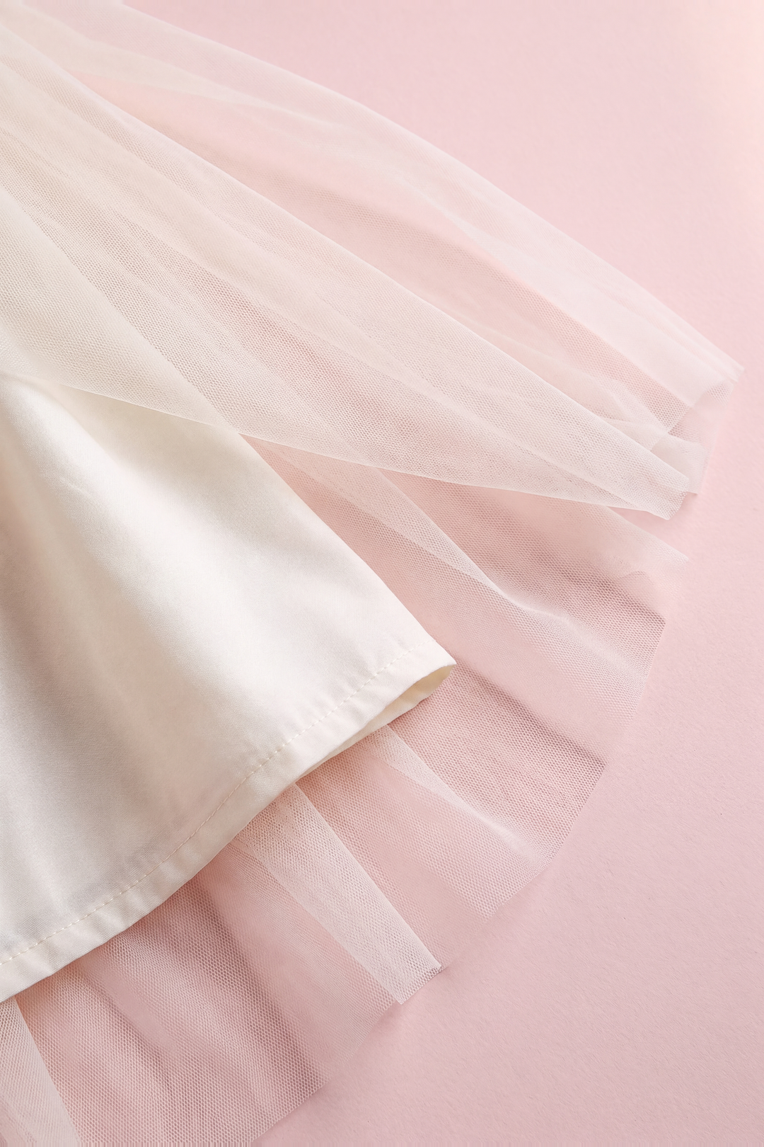Close up of the Snowdrop dress hem, layers of sheer ivory tulle over the cream lining