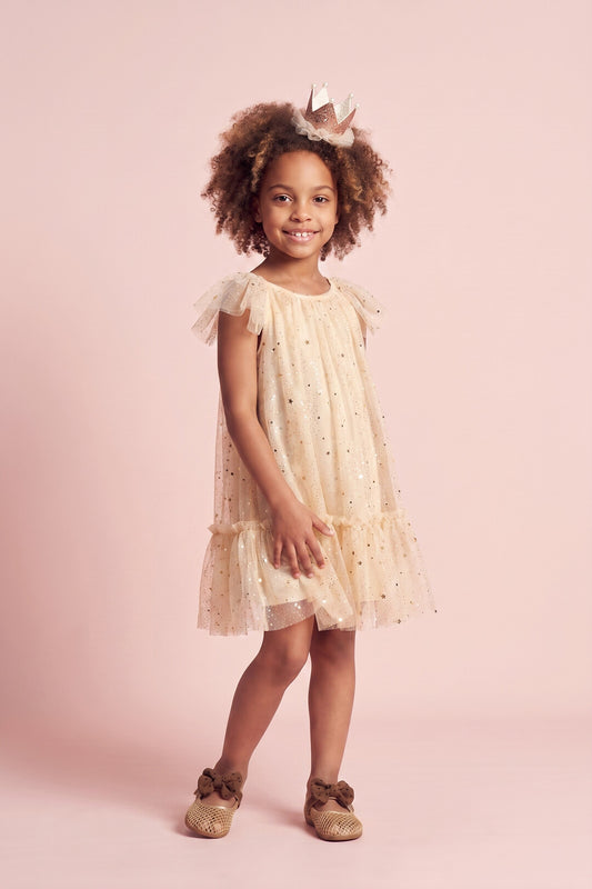 Girl wearing the Starlight Dress in cream gold star tulle, front